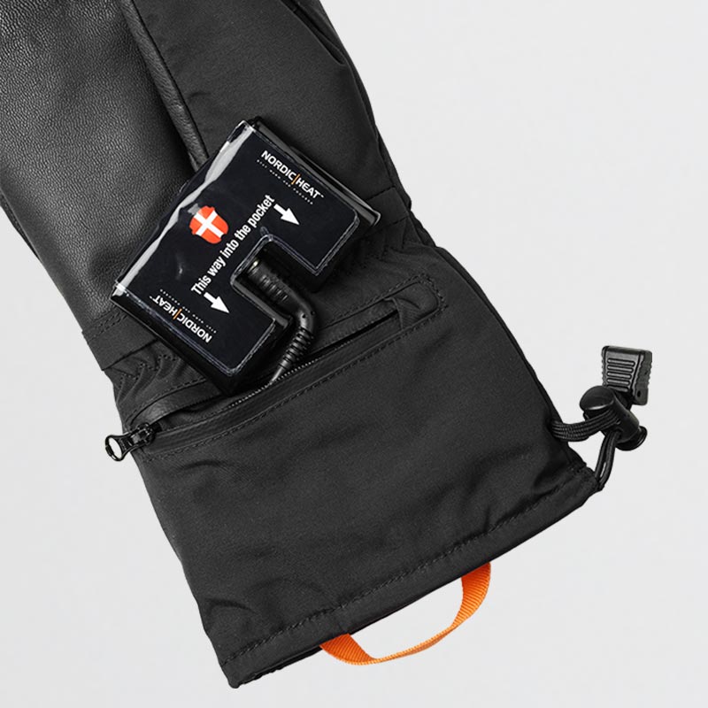 Sort handske med åbnet lomme viser indsat NordicHeat batteripakke. Tekst på batteripakke: "This way into the pocket" og "NORDICHEAT" med pil, ledsaget af dansk flag.