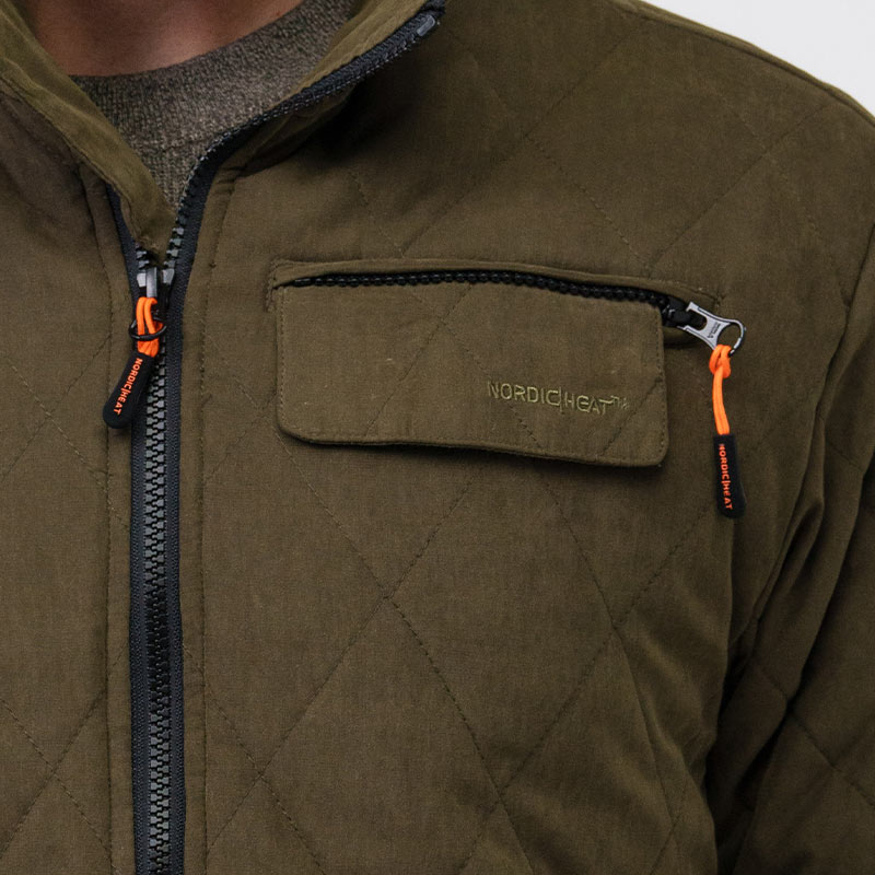 En brun, quiltet jakke med lynlåse og orange trækstropper. Logo "NORDICHEAT" ses på brystlommeklappen. Jakken bæres indendørs over en trøje.