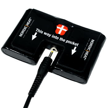 Et sort batteripakke til NordicHeat-varmetøj med stik er markeret med instruktioner: “This way into the pocket.” Dansk flag er synligt på pakken.